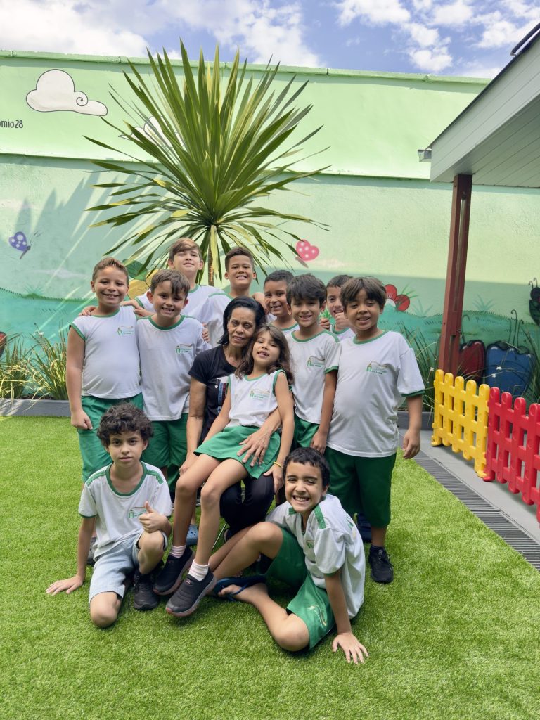 Turma de alunos com a professora no pátio da escola
